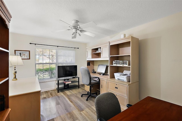 office area with a textured ceiling, light wood finished floors, and a ceiling fan