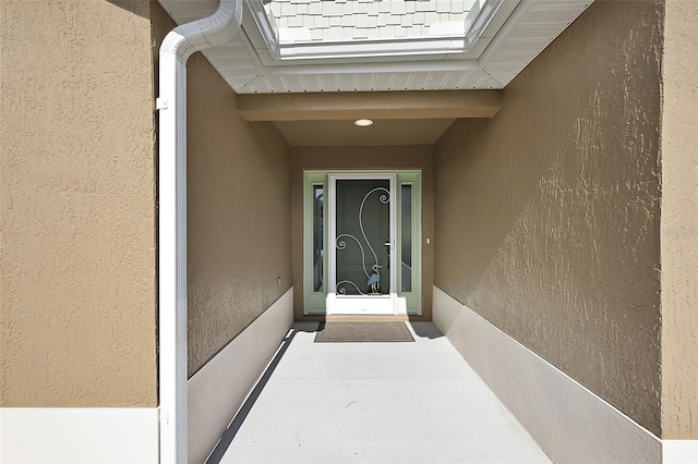 view of exterior entry with stucco siding