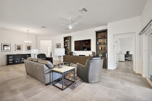 living area featuring light tile patterned floors, visible vents, and ceiling fan with notable chandelier