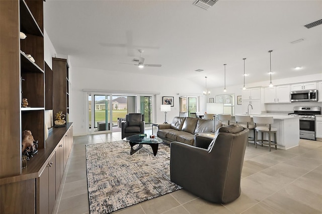 living area featuring a ceiling fan, lofted ceiling, visible vents, and light tile patterned floors