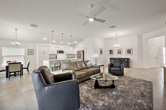 living room featuring lofted ceiling, ceiling fan with notable chandelier, visible vents, and light tile patterned flooring