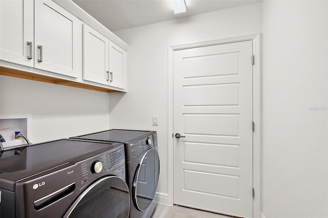 laundry room with baseboards, cabinet space, and washer and dryer