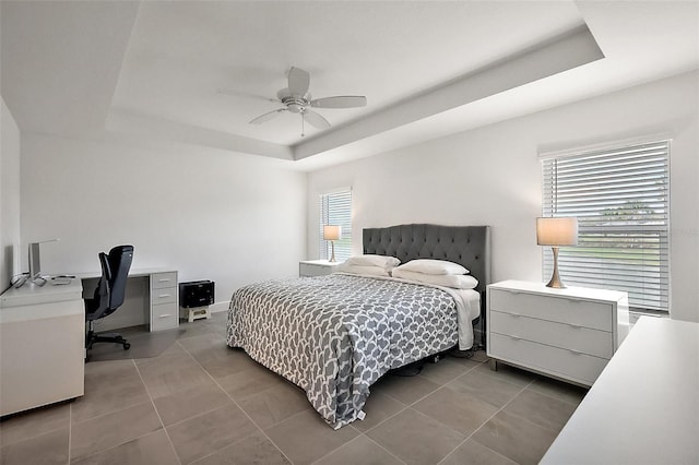 bedroom featuring tile patterned flooring, a raised ceiling, and ceiling fan