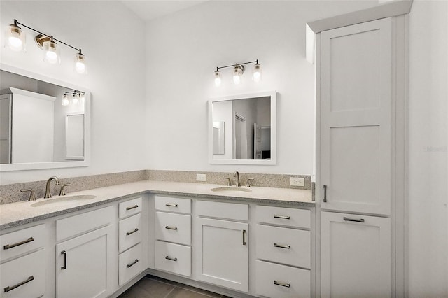 full bath featuring double vanity, a sink, and tile patterned floors