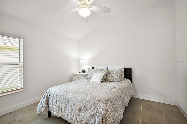 tiled bedroom featuring vaulted ceiling, a ceiling fan, and baseboards