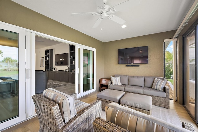 living area with a ceiling fan and light wood finished floors