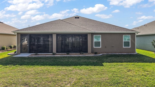 back of house featuring a sunroom, roof with shingles, a lawn, and stucco siding