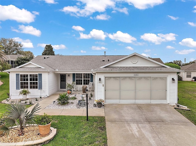 ranch-style house featuring an attached garage, a shingled roof, a front lawn, and concrete driveway