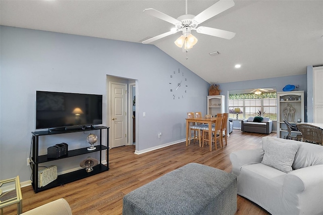 living room with vaulted ceiling, ceiling fan, baseboards, and wood finished floors