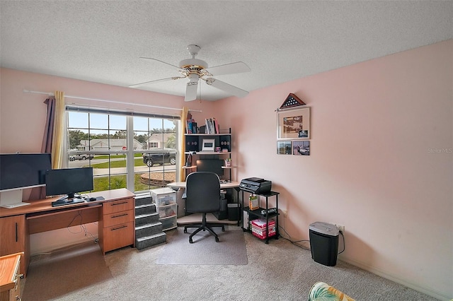 office featuring light carpet, ceiling fan, and a textured ceiling