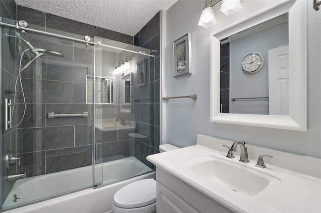 bathroom featuring a textured ceiling, bath / shower combo with glass door, vanity, and toilet