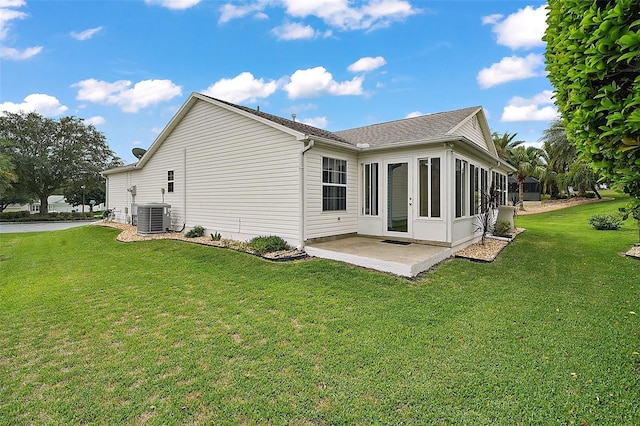 back of property with a yard, a patio area, a sunroom, and central air condition unit