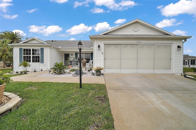 single story home with driveway, an attached garage, and a front yard