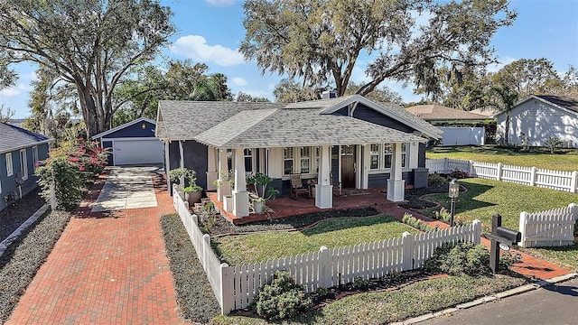 view of front of property featuring a fenced front yard, roof with shingles, decorative driveway, a front yard, and stucco siding