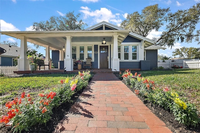 view of front of house with a porch, fence, and a front lawn