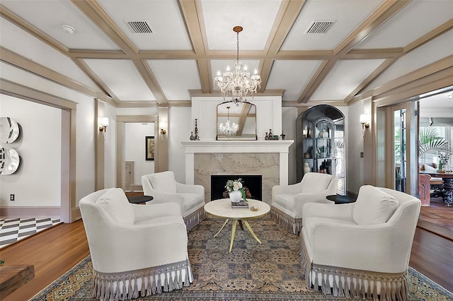 living area with vaulted ceiling with beams, a fireplace, visible vents, and a notable chandelier