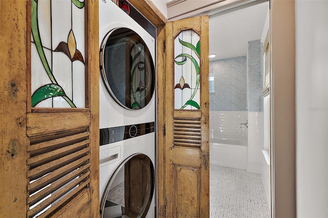 washroom featuring stacked washer and dryer and laundry area