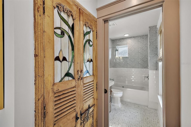 bathroom featuring tile patterned flooring, shower / tub combination, toilet, visible vents, and vanity