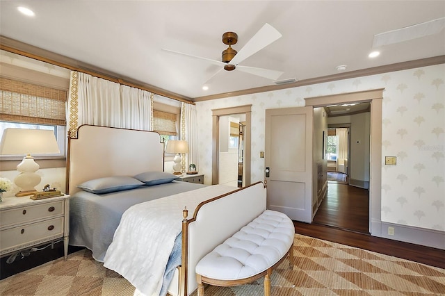 bedroom with visible vents, a ceiling fan, wood finished floors, baseboards, and wallpapered walls