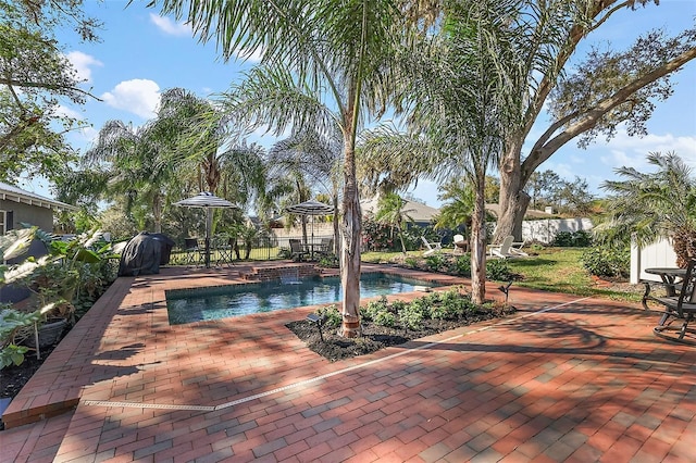 outdoor pool featuring fence and a patio