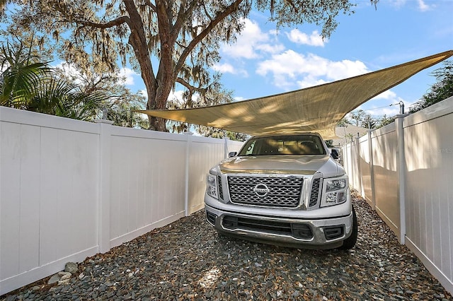 view of car parking with a fenced backyard and a carport