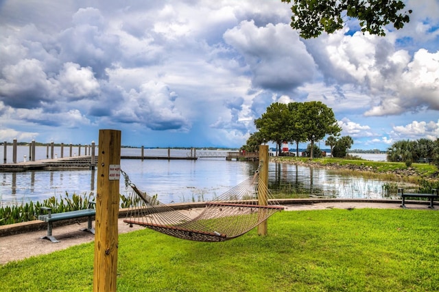 view of dock featuring a water view and a lawn