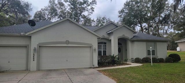 single story home featuring concrete driveway, roof with shingles, an attached garage, a front lawn, and stucco siding