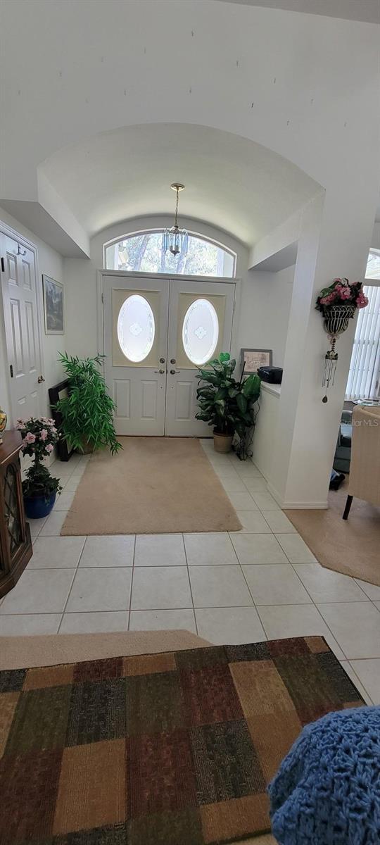 foyer entrance featuring vaulted ceiling and light tile patterned floors