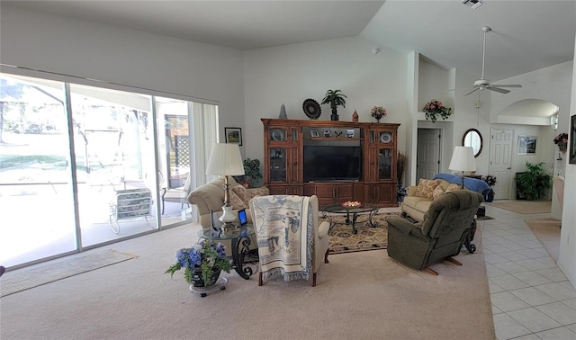 living area with light carpet, ceiling fan, visible vents, and high vaulted ceiling