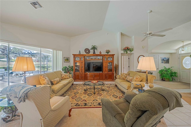 living area featuring light tile patterned floors, high vaulted ceiling, visible vents, and a ceiling fan