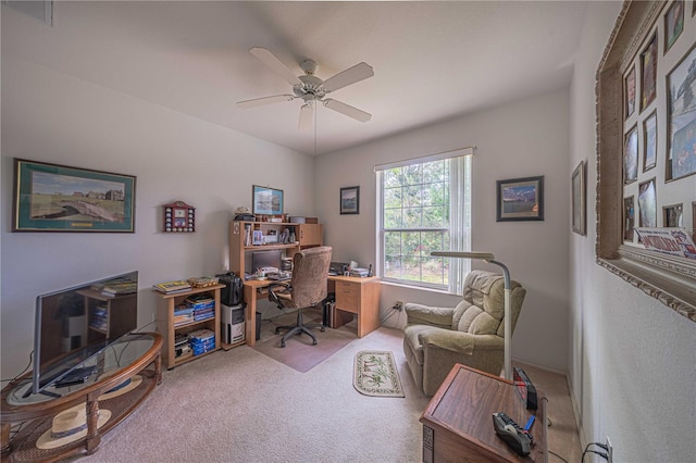 carpeted office space with ceiling fan