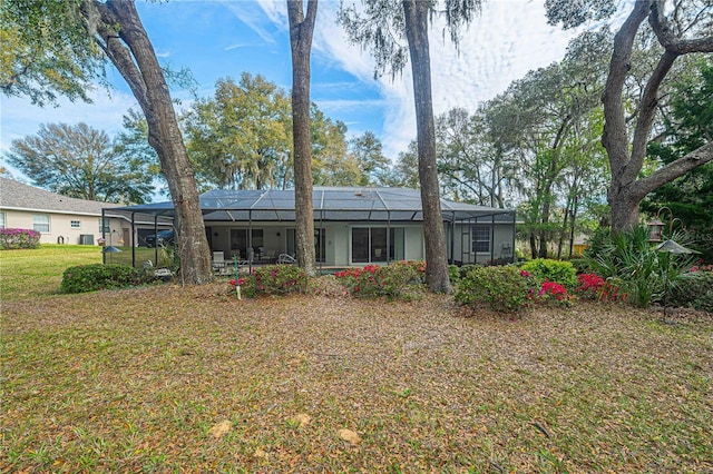 back of property with a yard and a lanai