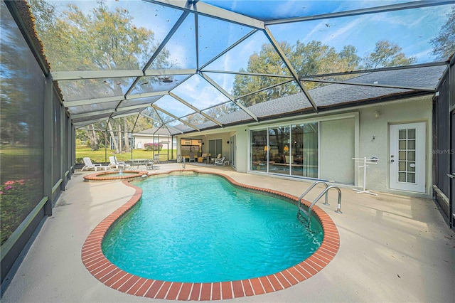 view of pool with glass enclosure, a patio area, and a pool with connected hot tub