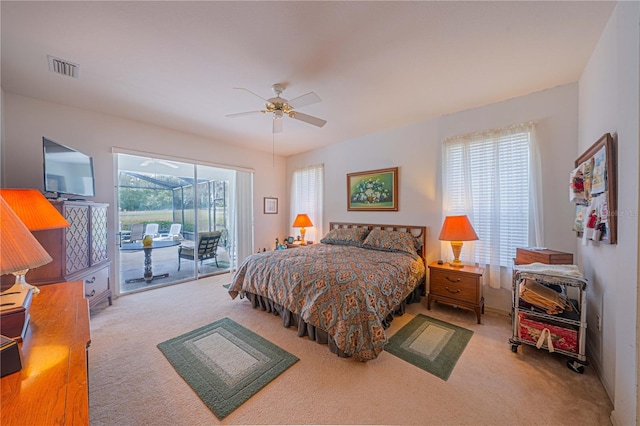 carpeted bedroom with a sunroom, access to outside, visible vents, and a ceiling fan