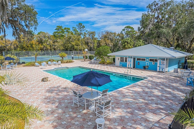 pool with a patio and fence