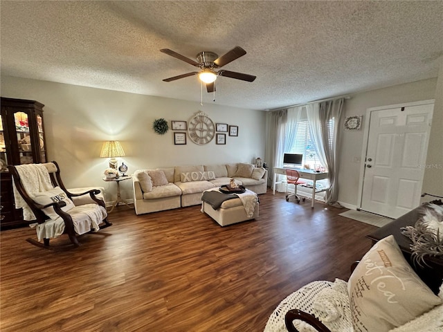 living area featuring dark wood-style floors, a textured ceiling, a ceiling fan, and baseboards