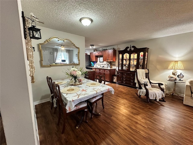 dining room featuring dark wood-type flooring, a textured ceiling, and baseboards