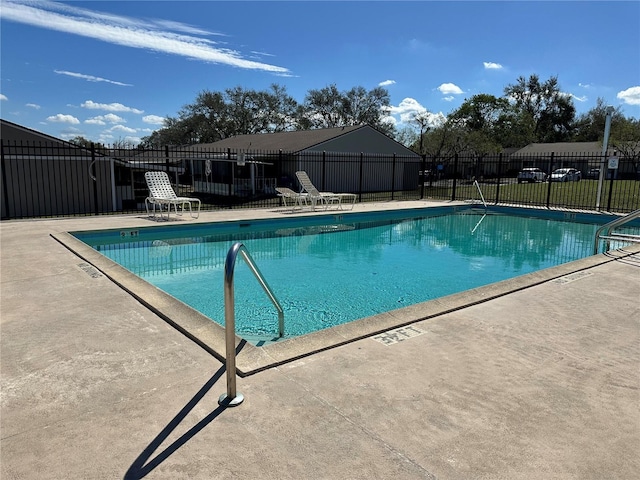 pool with a patio area and fence