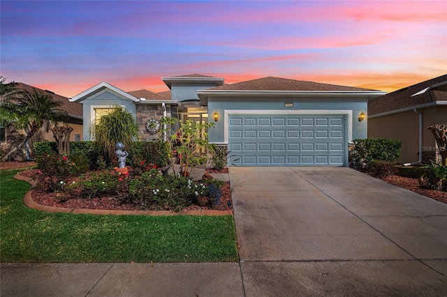 view of front of property with a garage, concrete driveway, and stucco siding