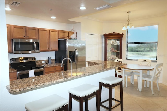 kitchen with stainless steel appliances, brown cabinetry, visible vents, and crown molding