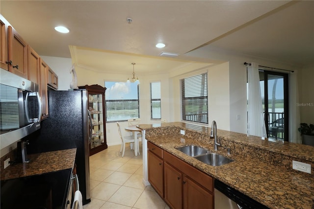 kitchen with light tile patterned floors, appliances with stainless steel finishes, brown cabinets, ornamental molding, and a sink