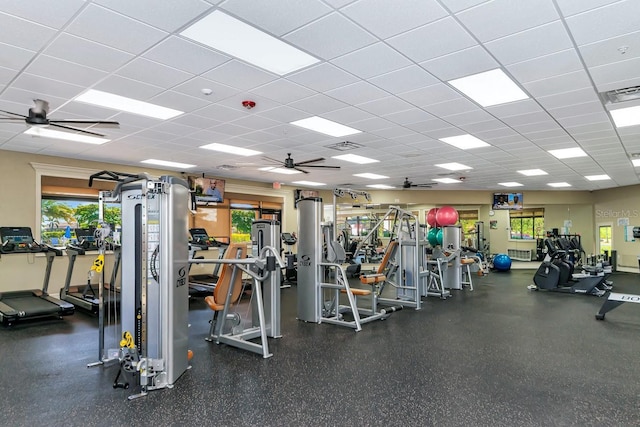 exercise room with a ceiling fan, a paneled ceiling, and visible vents