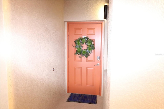 doorway to property featuring stucco siding