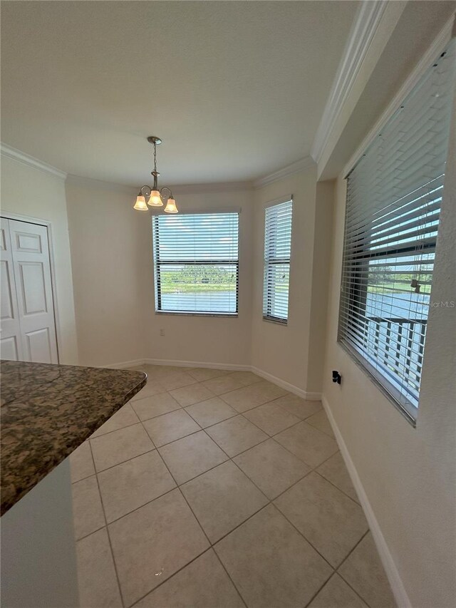 7005 River Hammock Dr Unit 207, Bradenton, FL 34212 - unfurnished dining area featuring crown molding, light tile patterned floors, and a chandelier