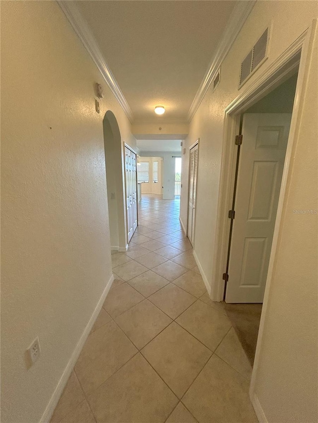 7005 River Hammock Dr Unit 207, Bradenton, FL 34212 - hallway featuring arched walkways, ornamental molding, and light tile patterned flooring