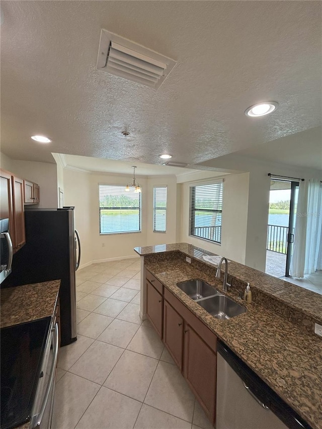 7005 River Hammock Dr Unit 207, Bradenton, FL 34212 - kitchen with appliances with stainless steel finishes, a textured ceiling, light tile patterned flooring, recessed lighting, and dark stone counters