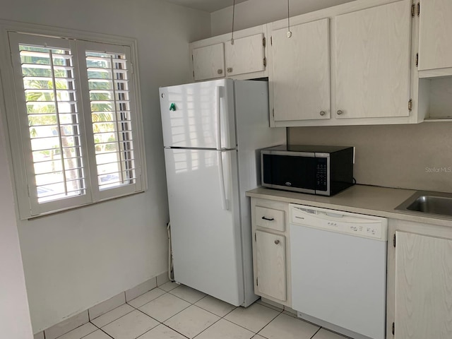 kitchen with white appliances, light countertops, plenty of natural light, and light tile patterned floors