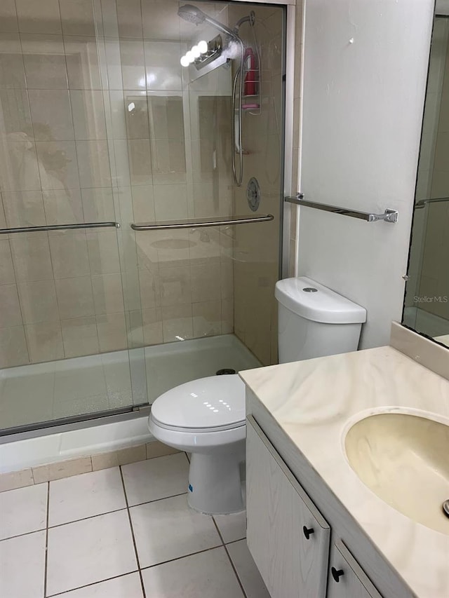 full bath with vanity, tile patterned flooring, a shower stall, and toilet