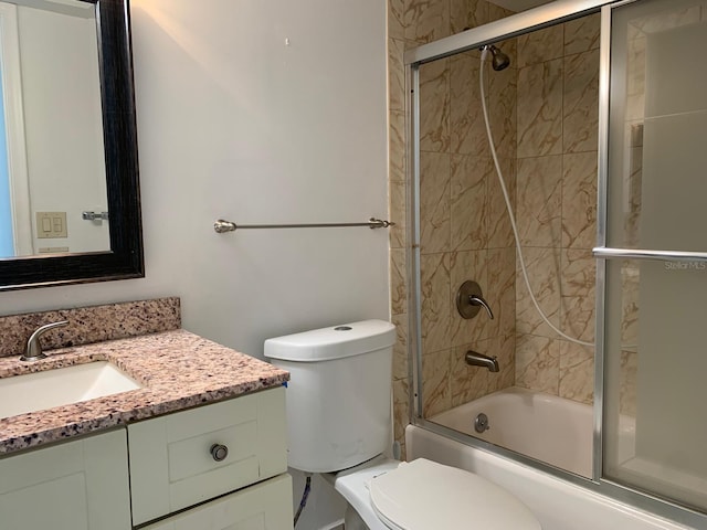 full bathroom featuring toilet, combined bath / shower with glass door, and vanity