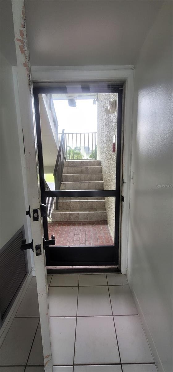 entryway with stairs and tile patterned floors